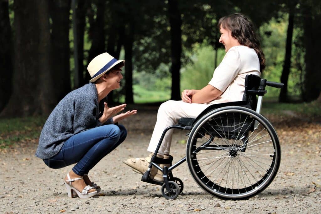 A woman talking to another woman on a wheelchair