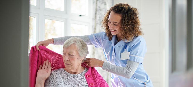 A Nurse helps an elderly woman living with dementia