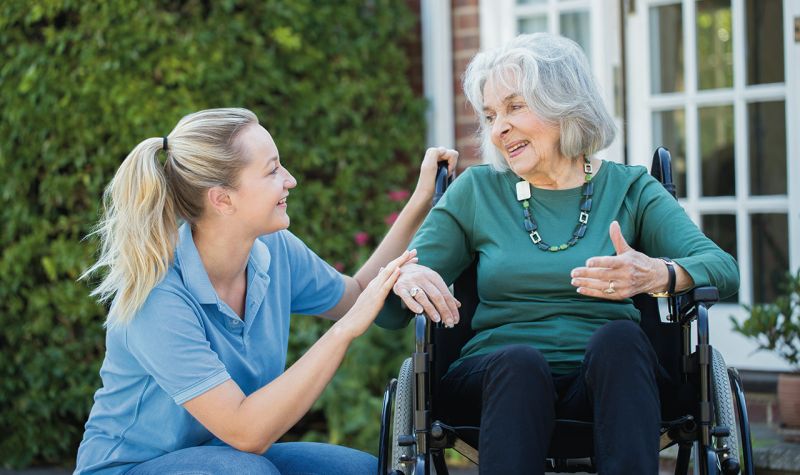 A care worker smiling at a residents demonstrating care and good support.