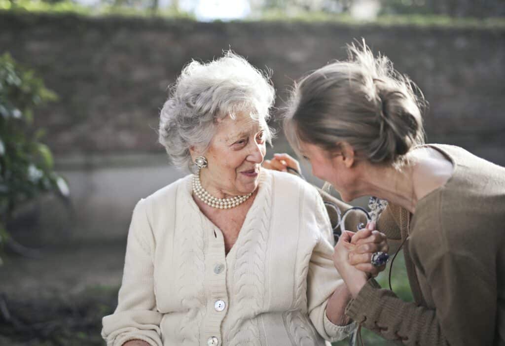 A care worker and an adult smiling and exchanging communication