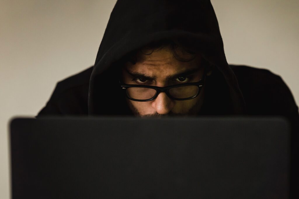 A man who is an hacker on a laptop paying attention to his work