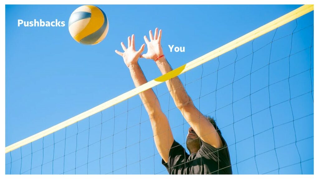 Man trying to defend while playing volleyball.