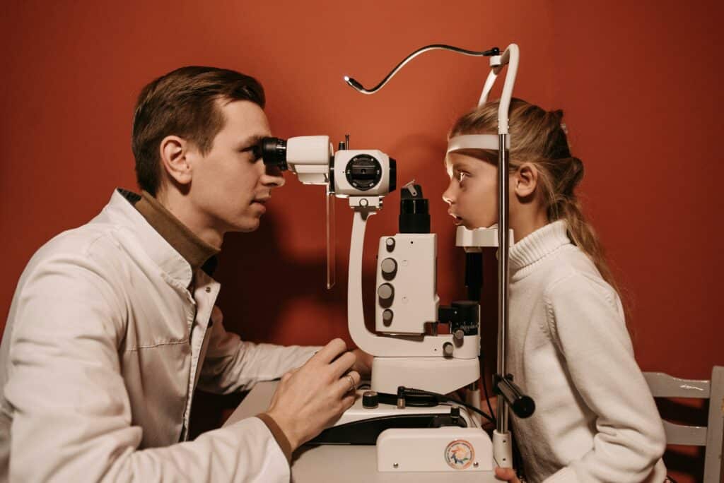 An eye doctor examining the eyes of a young patient in the hospital