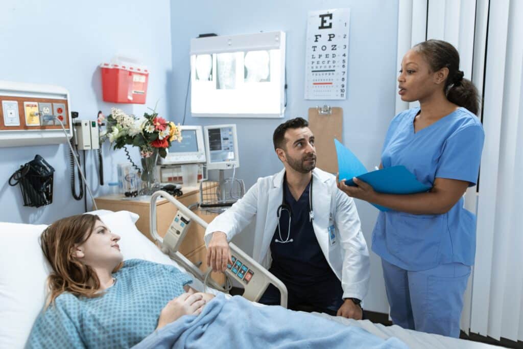 nurse and doctor talking to a patient